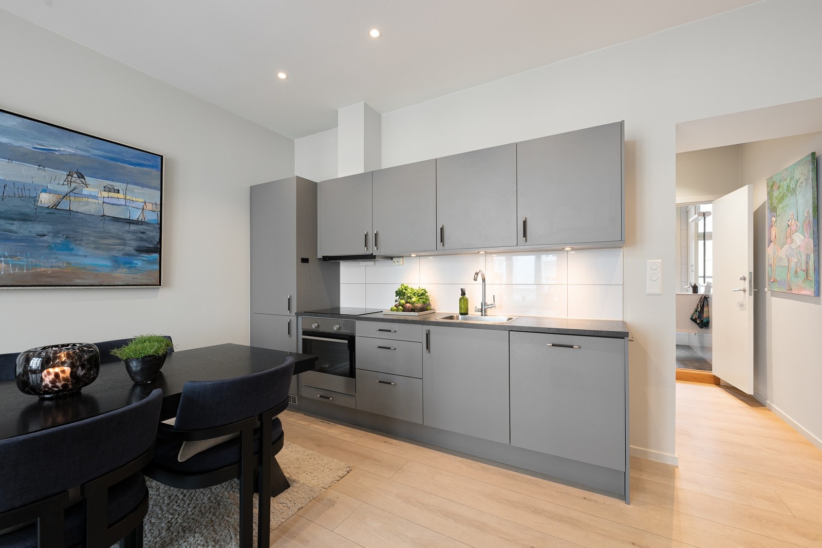 Kjøkkeninnredning fra HTH med glatte grå fronter på skuffer og skap. Galleribilde