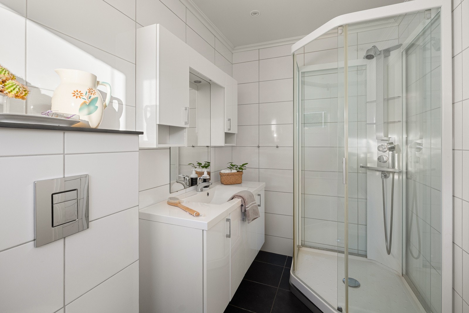 Badet har fliser på gulv med varmekabel, servant, vegghengt toalett og badekar - et praktisk og komfortabelt bad. Galleribilde