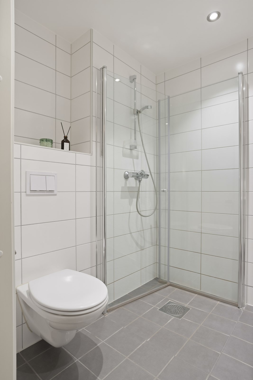 Badet er innredet med servantskap glatte fronter og heldekkende servant. Speil og lysarmatur på vegg over servant. Veggmontert klosett. Dusjhjørne med rette svingdører, sluk og termostatstyrt blandebatteri. Galleribilde