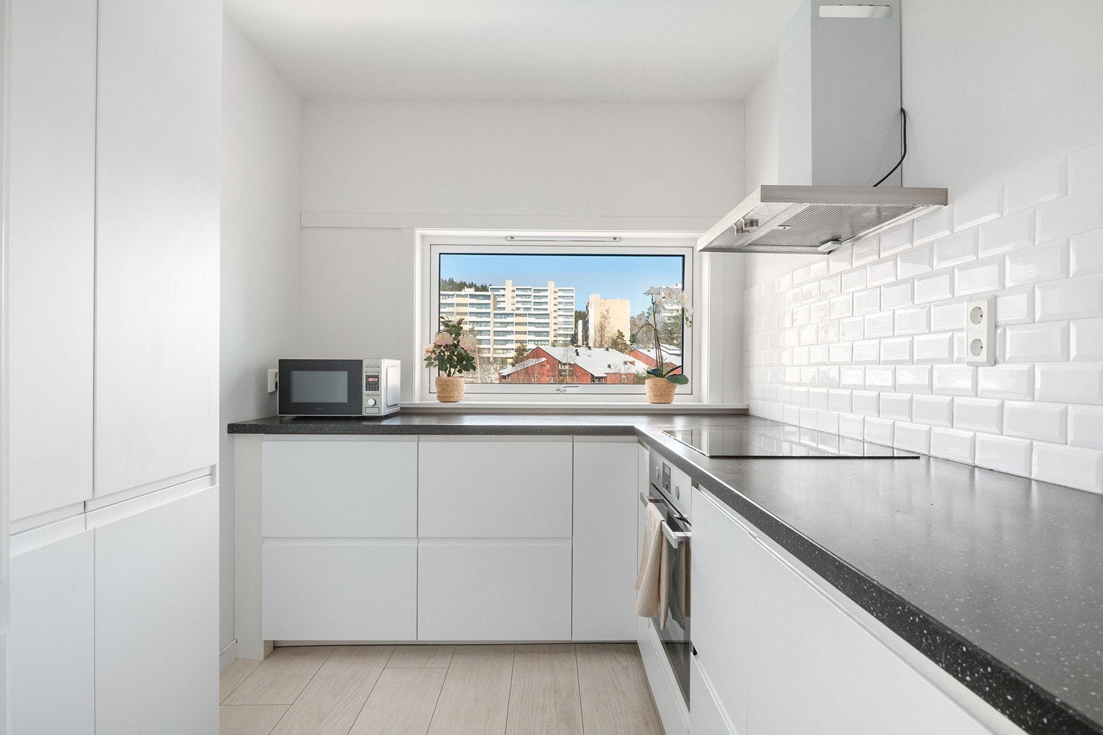 Laminat benkeplate med fliser over benk, nedfelt kum, integrert komfyr, induksjon platetopp, oppvaskmaskin og kjøl/fryseskap. Galleribilde