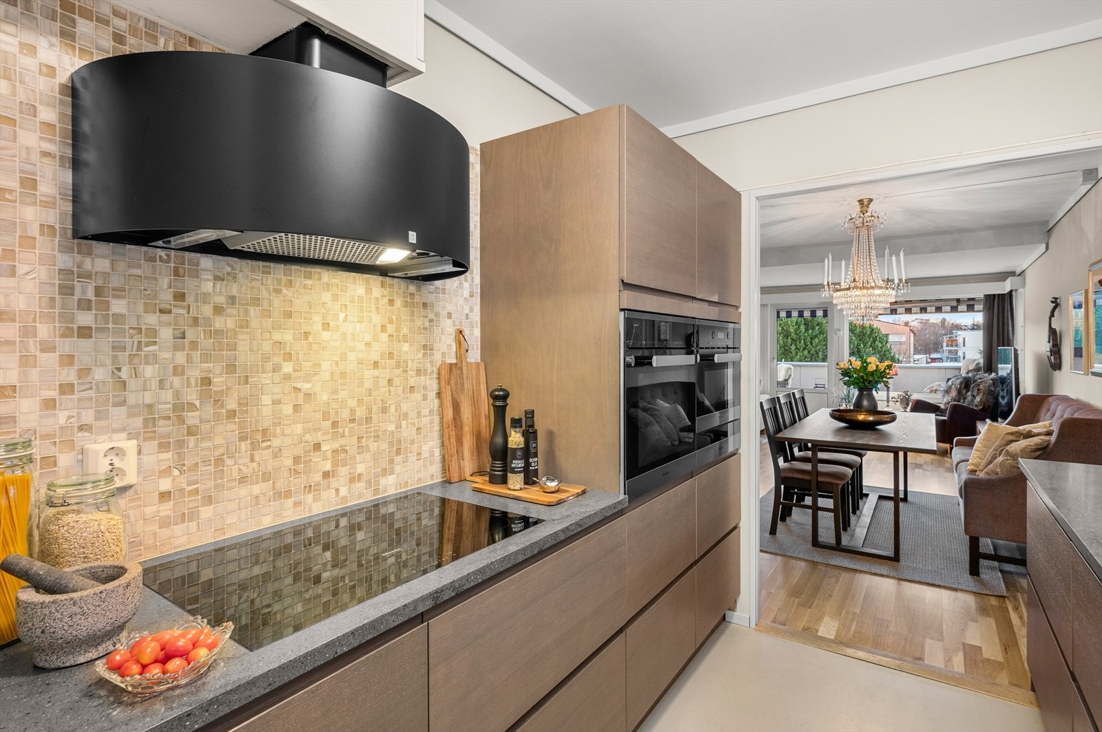 Videre er kjøkken utstyrt med Corian benkeplate, handlaget italiensk glassflis ved stekesone og alle skap og skuffer med soft-close Galleribilde