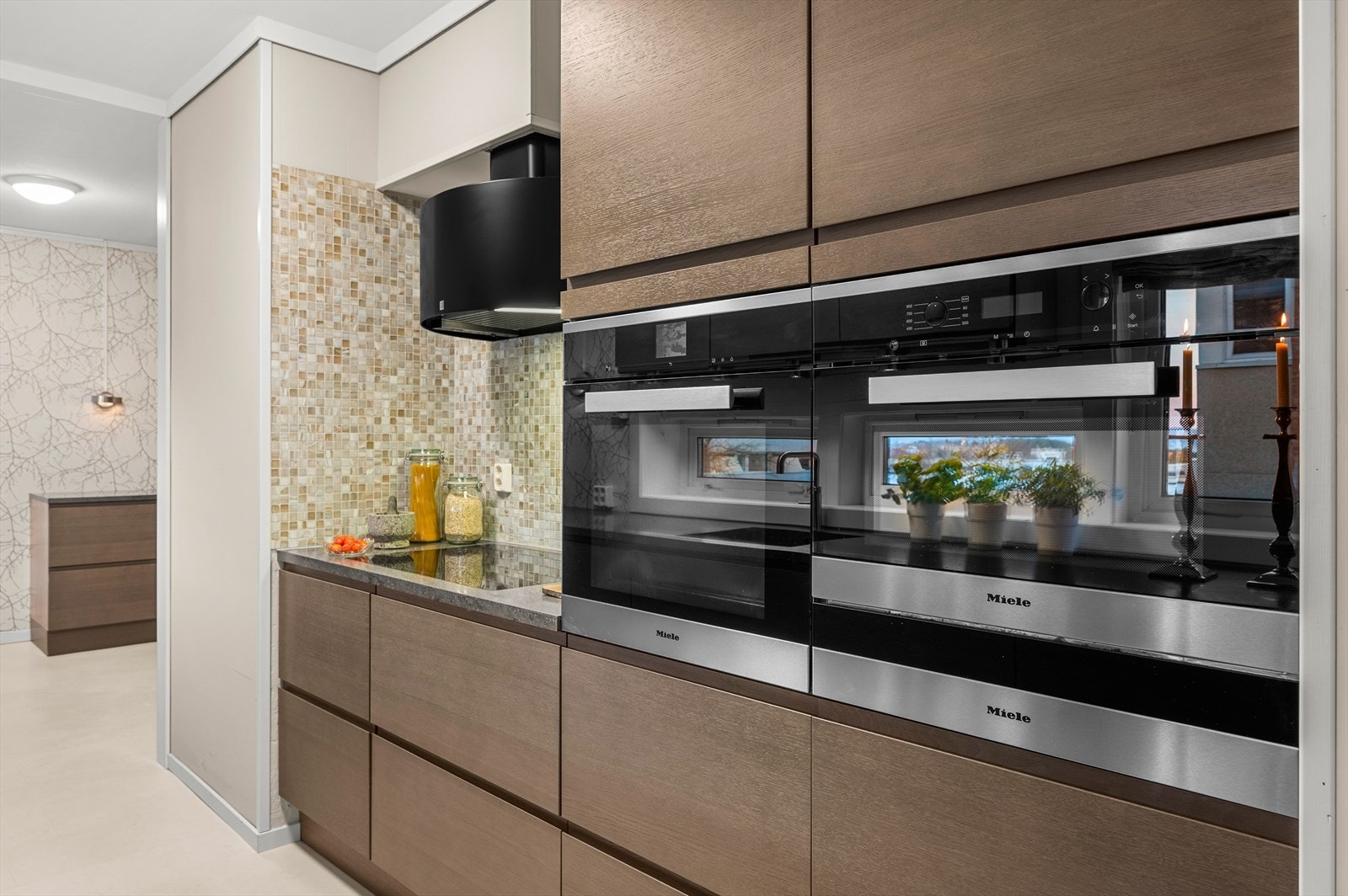 Her er det integrerte hvitevarer fra kvalitetsleverandøren Miele: Kombi stek/damp, mikro, varmeskuffe, platetopp 75 cm med induksjon og boost samt oppvaskmaksin med bestikkskuff Galleribilde