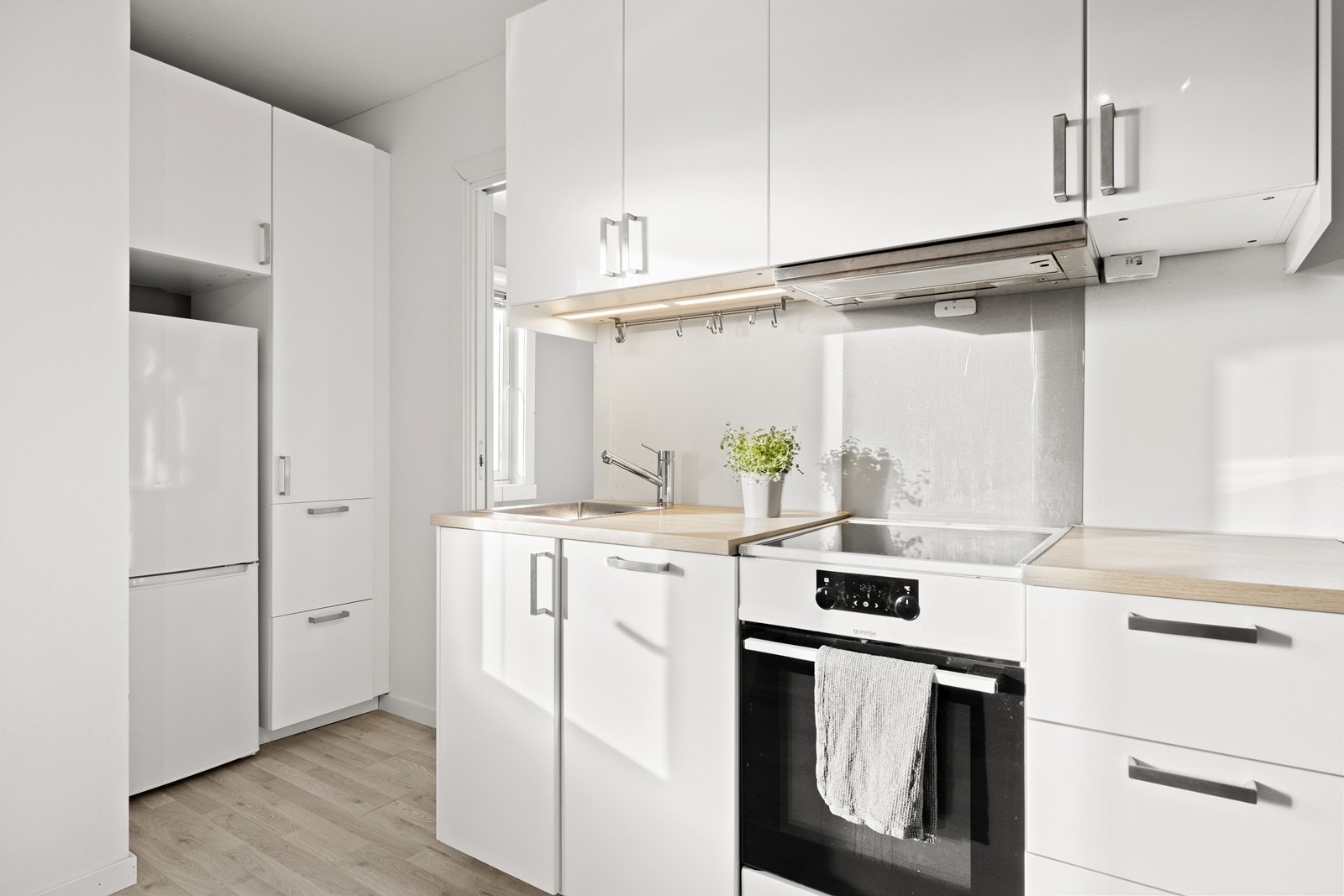 Kjøkkeninnredningen fra 2020 har slette fronter, laminat benkeplate og integrert oppvaskmaskin. Galleribilde