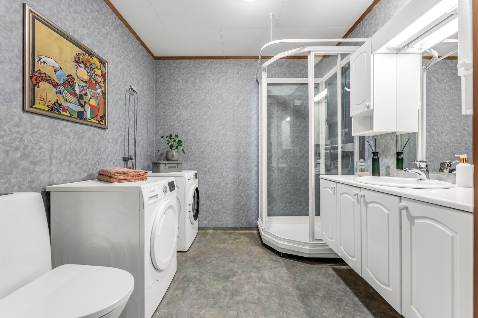 Pent bad med dusjkabinett, wc, innredning med servant og opplegg for vaskemaskin. Galleribilde
