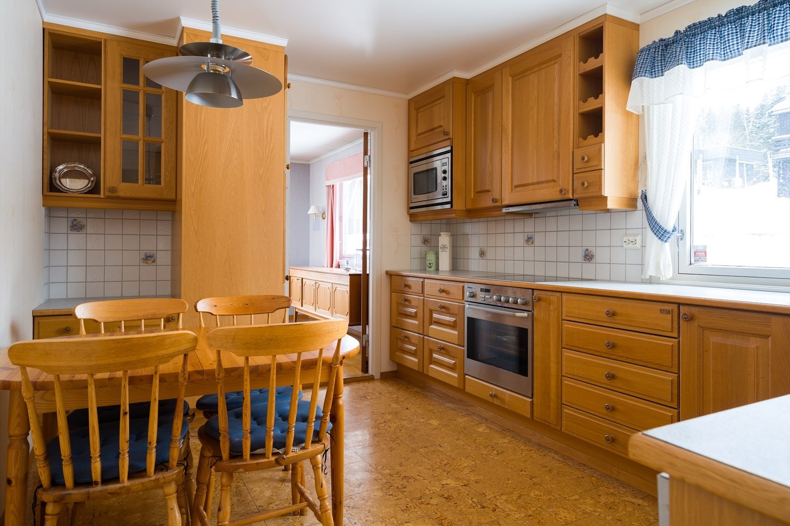 Kjøkkenet er utformet i en praktisk L-form. Det er laminert benkeplate med nedfelt oppvaskkum og integrert komfyr. Galleribilde