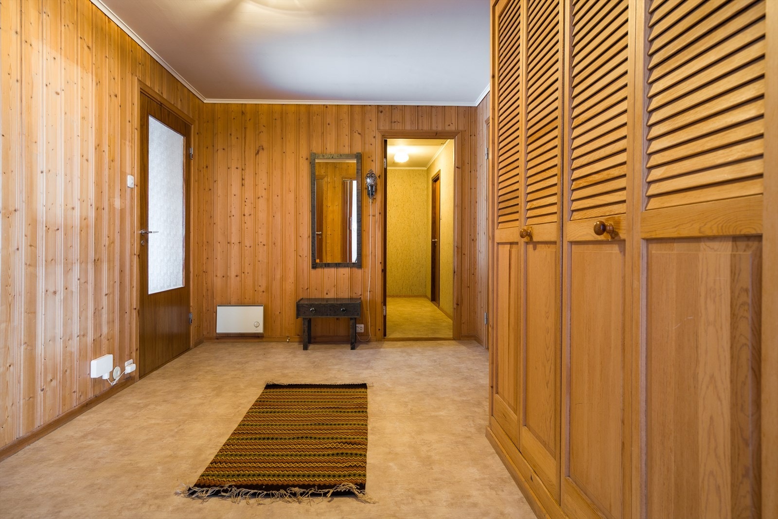 Gulvbelegget gir en varm atmosfære i gangen, med god oppbevaringsplass i innebygde skap. Galleribilde