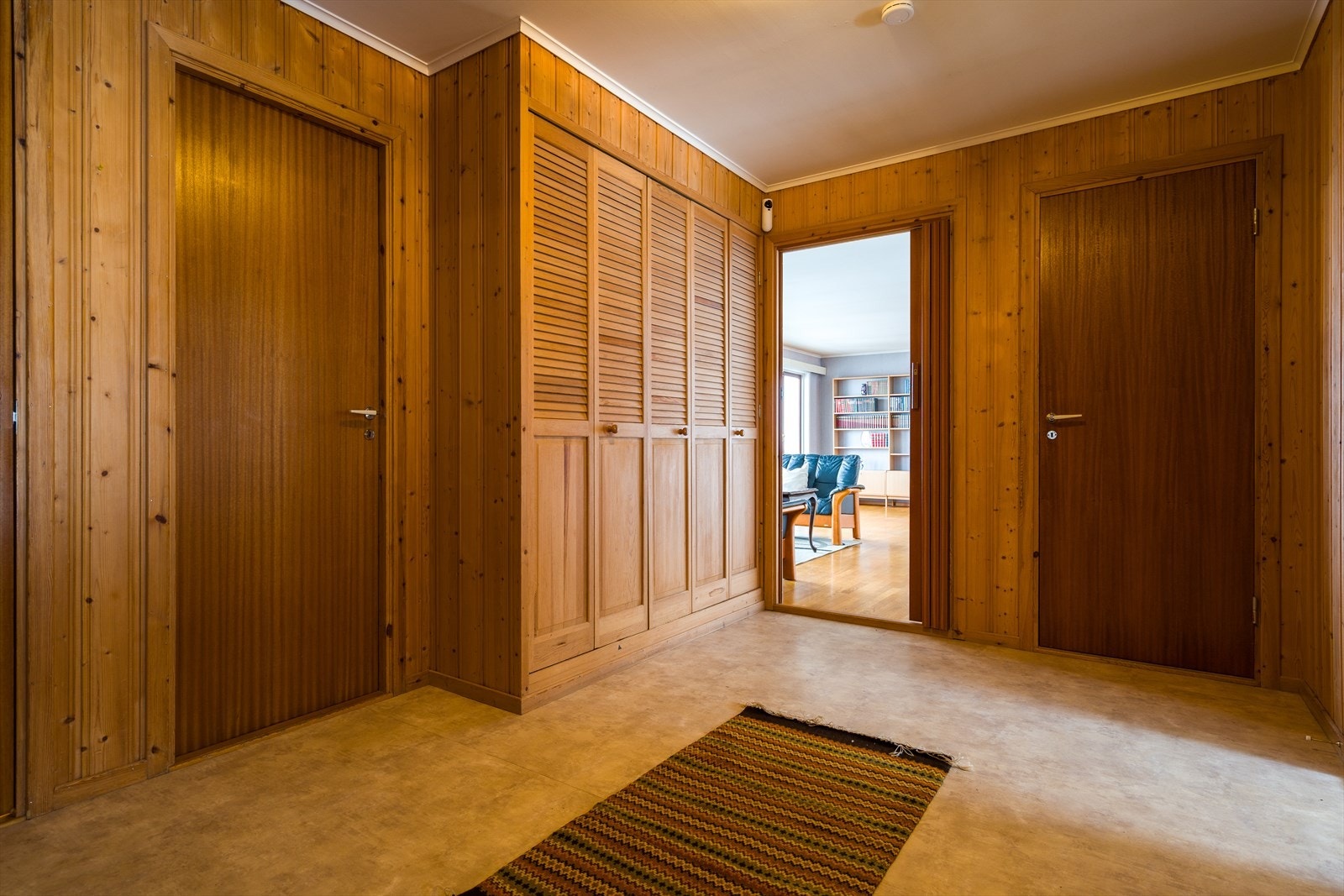 Panelvegger og innfelte skap gir praktisk oppbevaring i gangen. Galleribilde