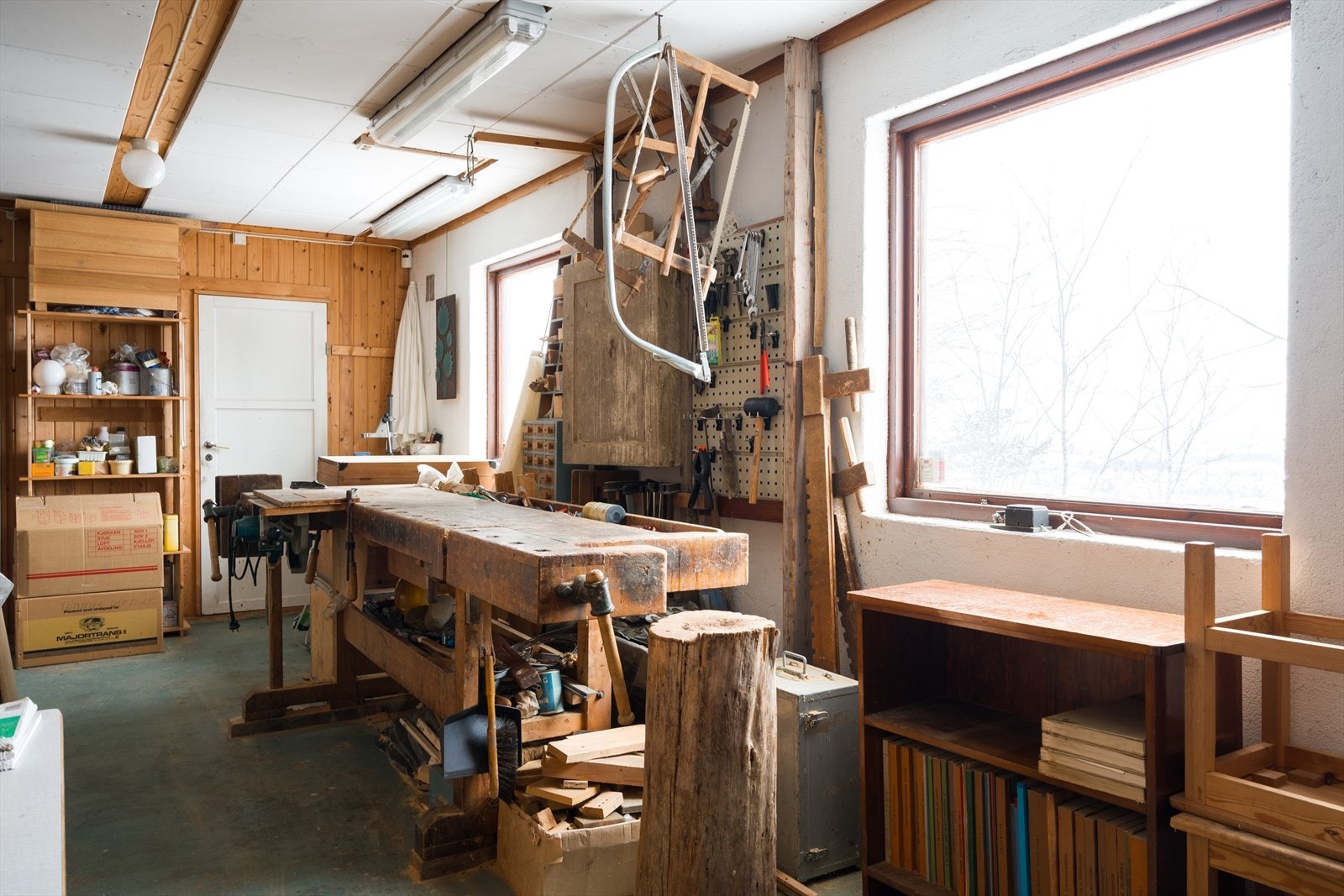 Solid arbeidsbenk og veggoppheng for verktøy gir praktisk oppbevaring i verkstedet. Galleribilde