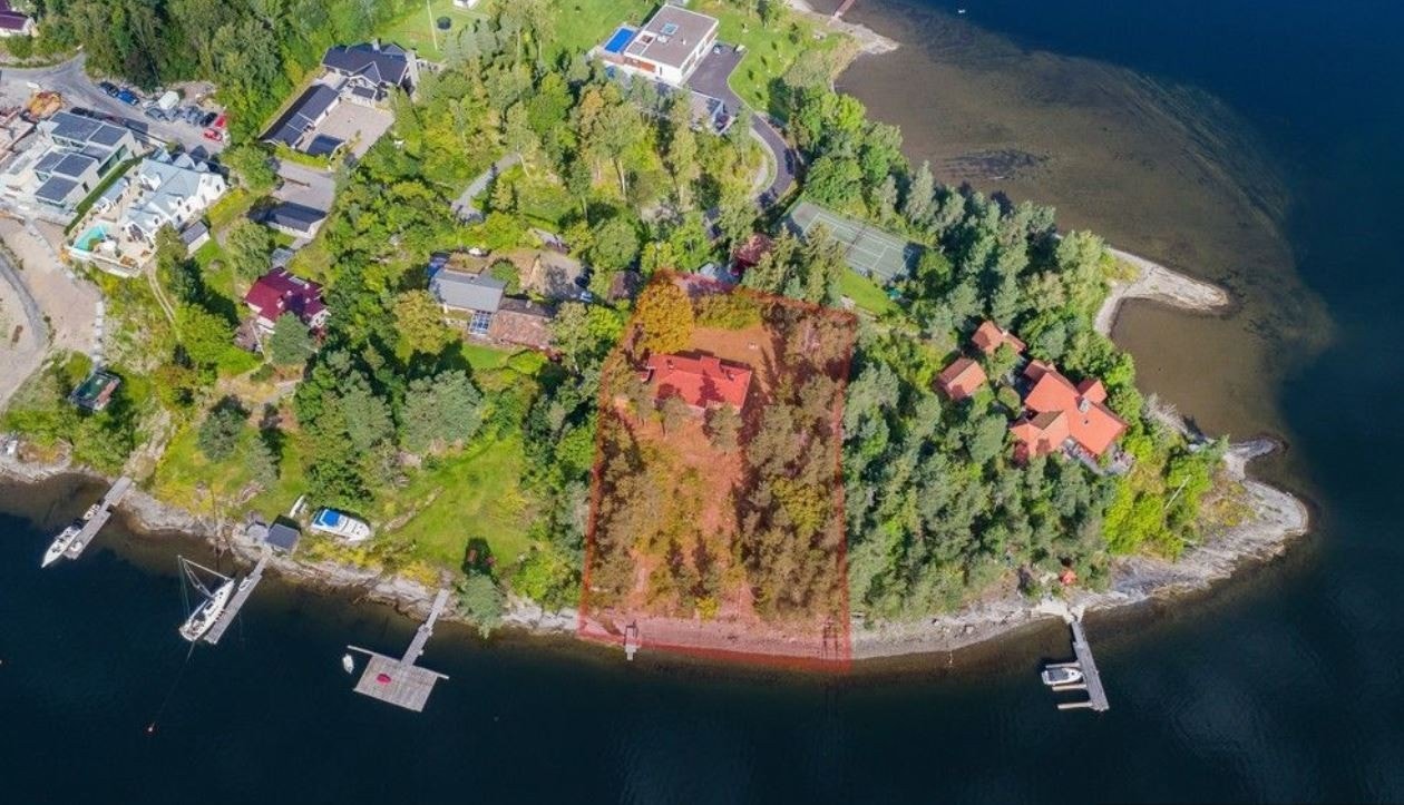 Oversikt over eiendommen- flyfoto. Se rødt merket område for tomt og strandlinje. Galleribilde