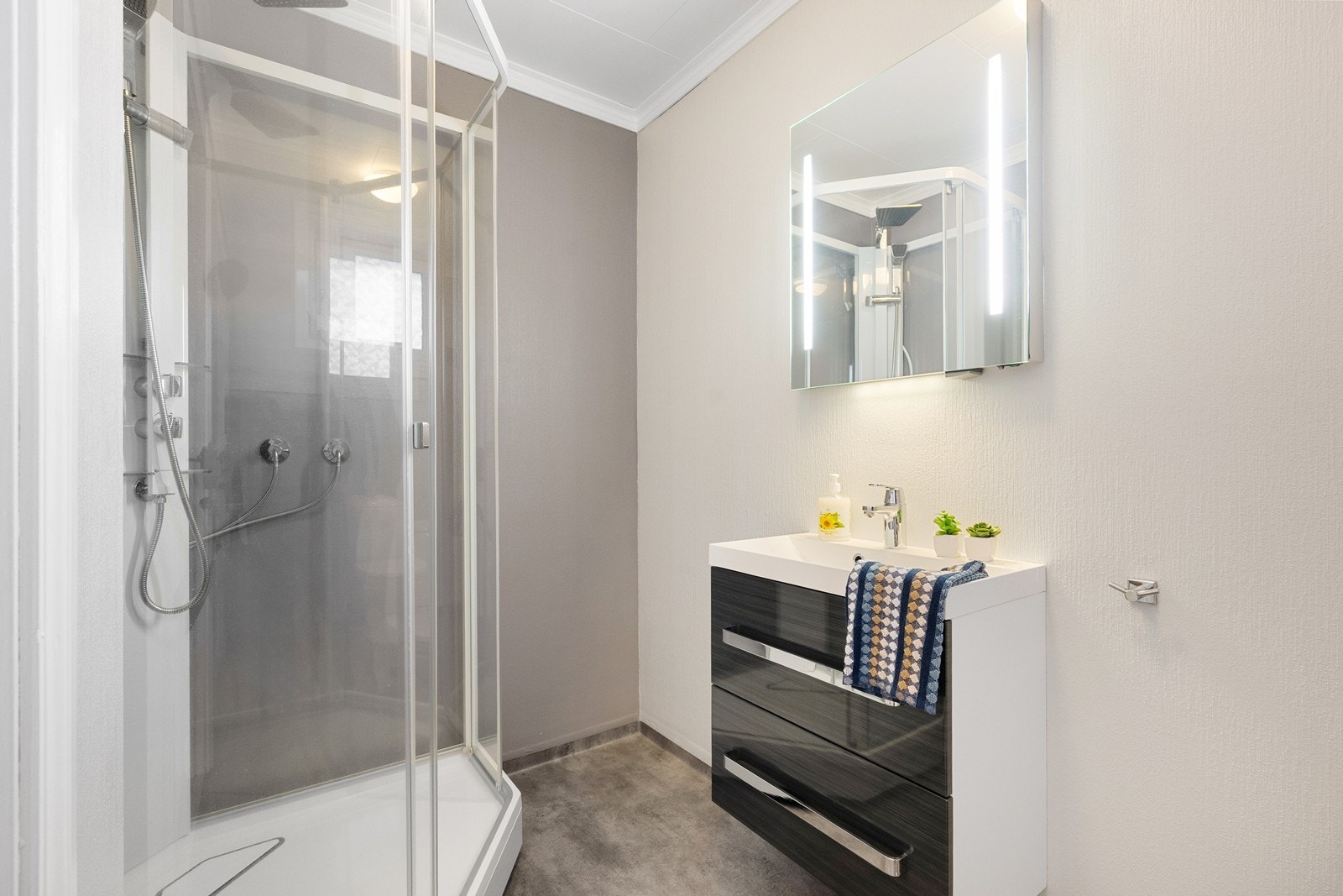Badet i 1. etasje har dusjkabinett, vask med skuffeseksjon og toalett. Galleribilde