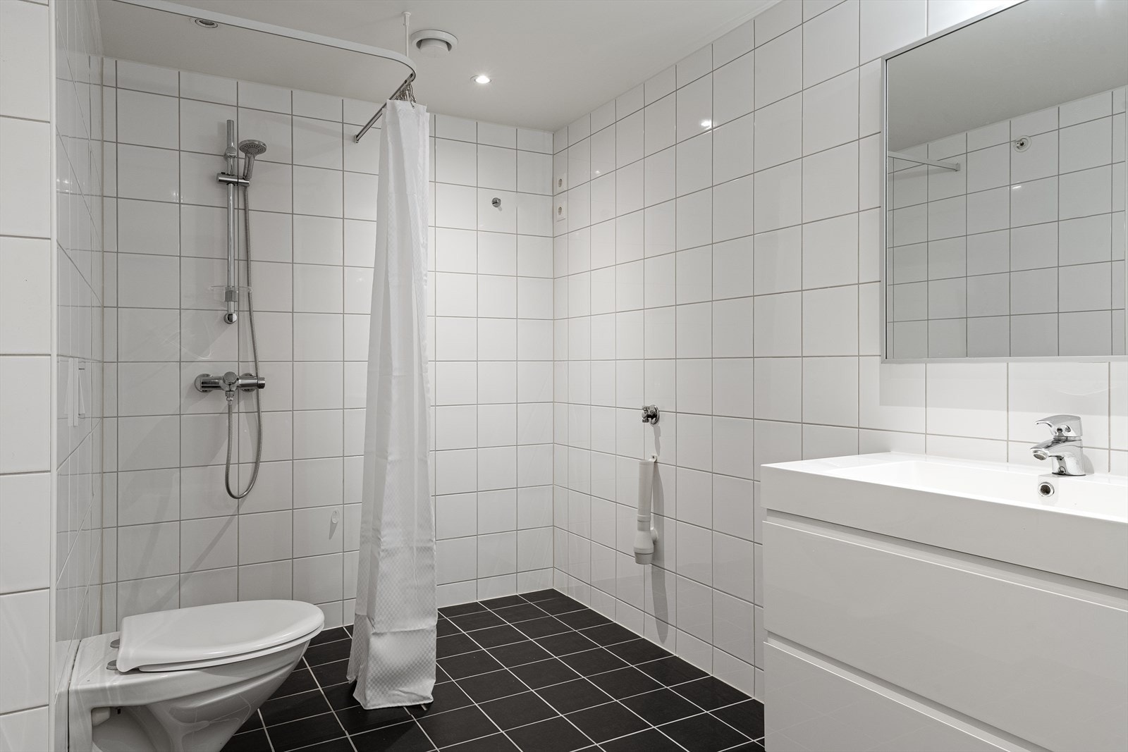 Badet er utstyrt med vegghengt toalett og romslig servantmøbel. Galleribilde