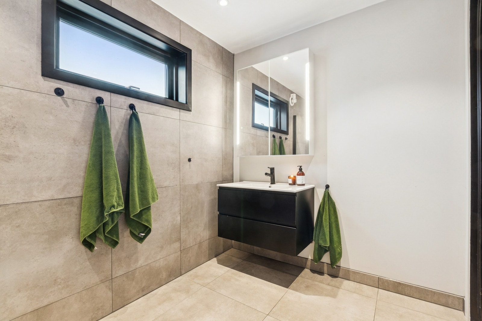 Her er det lagt store, stilrene fliser, integrerte LED-spotter og elektriske varmekabler Galleribilde