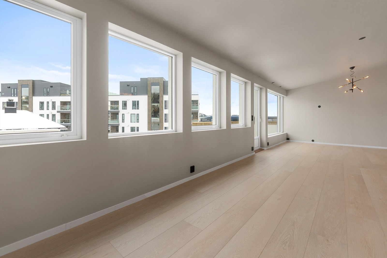 Stue med store vinduer som gir god utsikt over nærområdet. Perfekt for moderne komfort og trivsel. Galleribilde