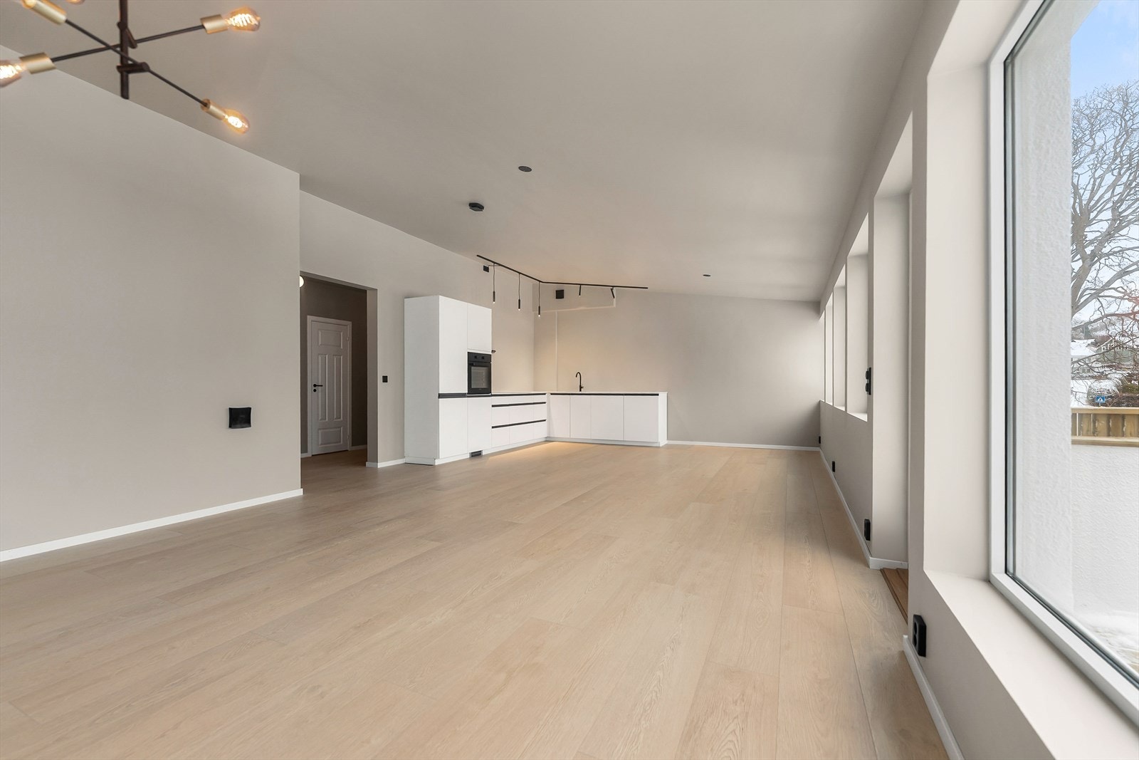 Stor stue mot kjøkken med gode valgmuligheiter for møblering Galleribilde