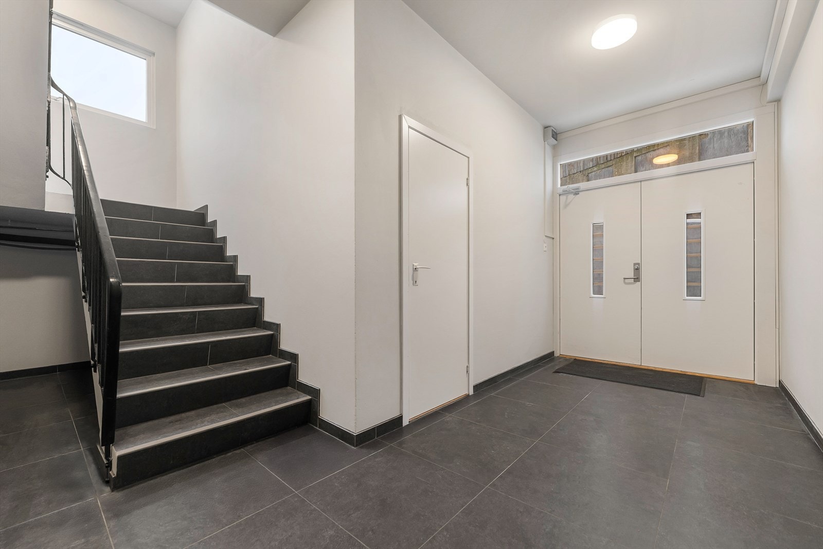 Lys og luftig trappeoppgang med moderne golvfliser og praktisk trappeadkomst. Galleribilde