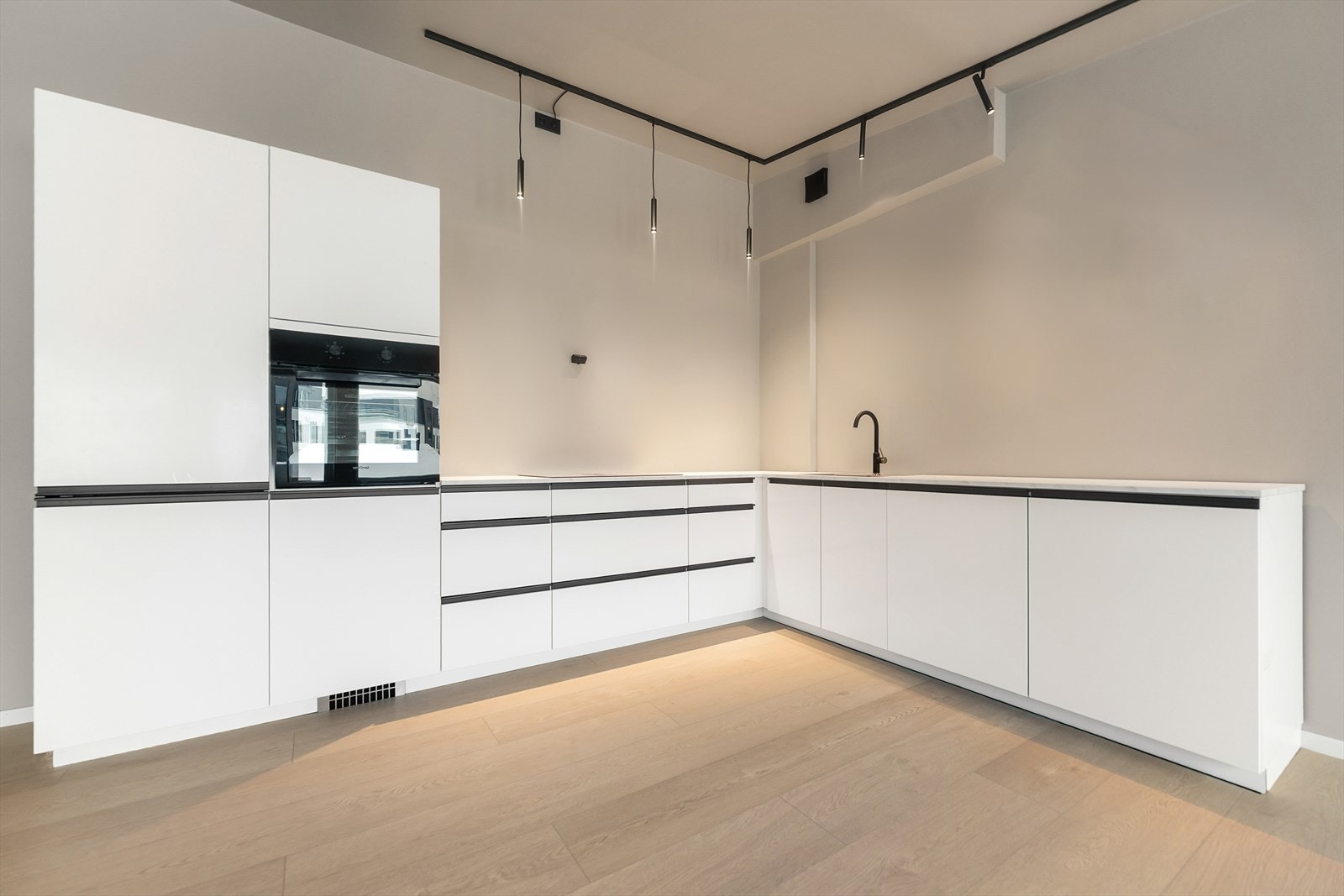 Moderne kjøkken med stilrent design, integrerte hvitevarer og god belysning. Galleribilde