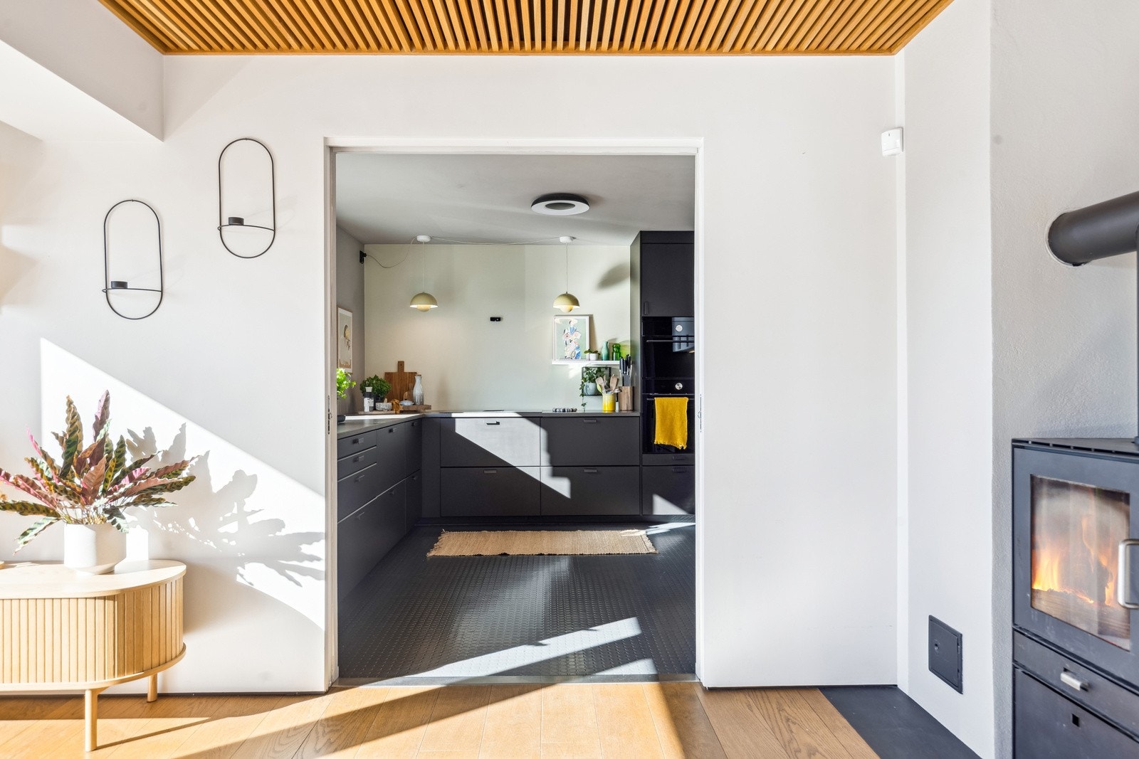 Praktisk adgang til kjøkkenet - I kontrast til den lyse stuen er kjøkkenfrontene glatte med en dempet sort farge. Galleribilde