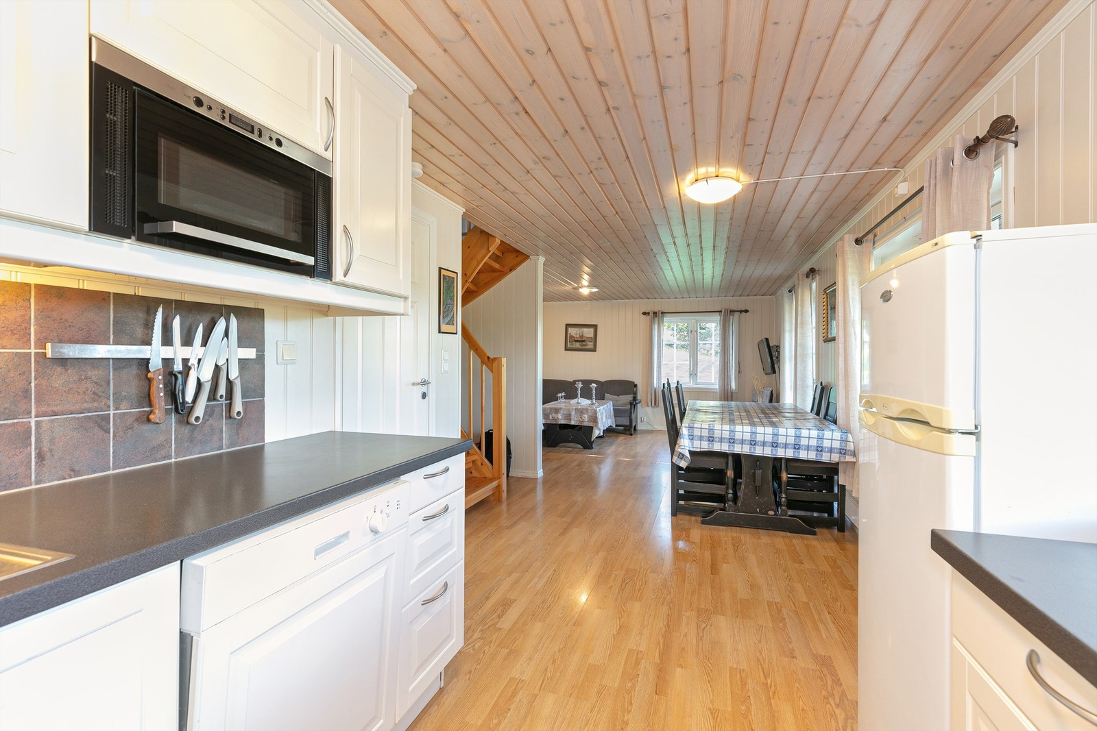 Boligen har en åpen løsning mellom stue og kjøkken Galleribilde