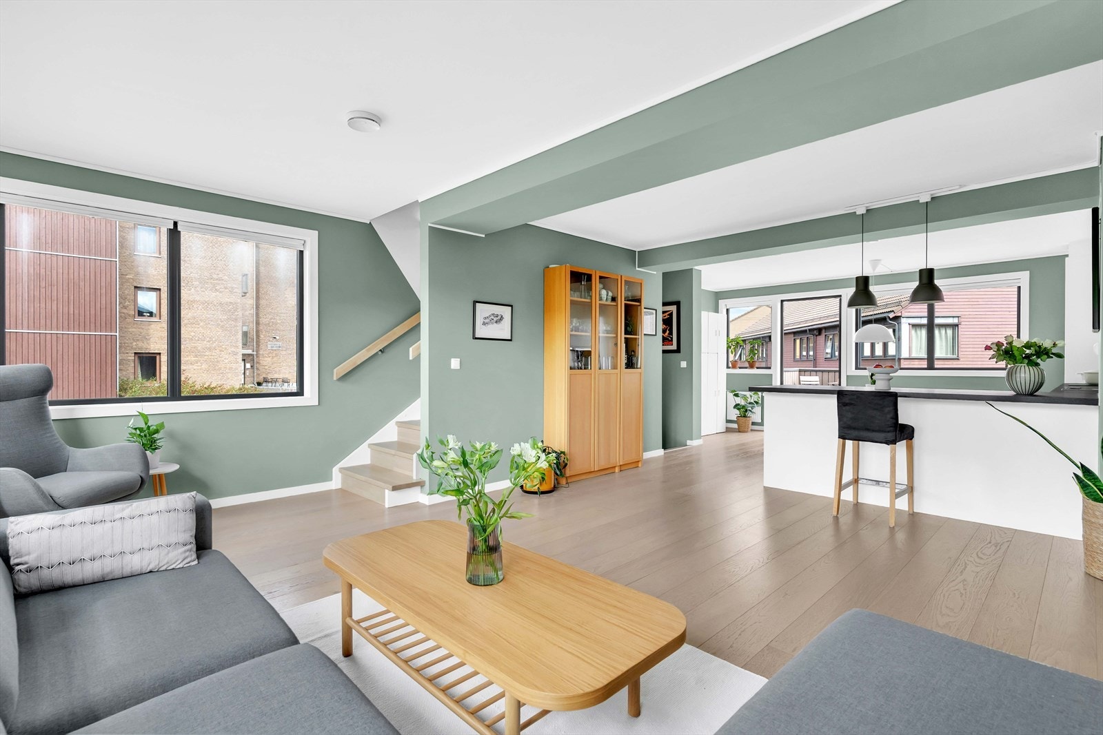 Det er åpen løsning mellom stue og kjøkken. Rommet oppleves som både lyst og luftig, mye takket være at boligen er et hjørnerekkehus med vinduer på tre sider. Galleribilde