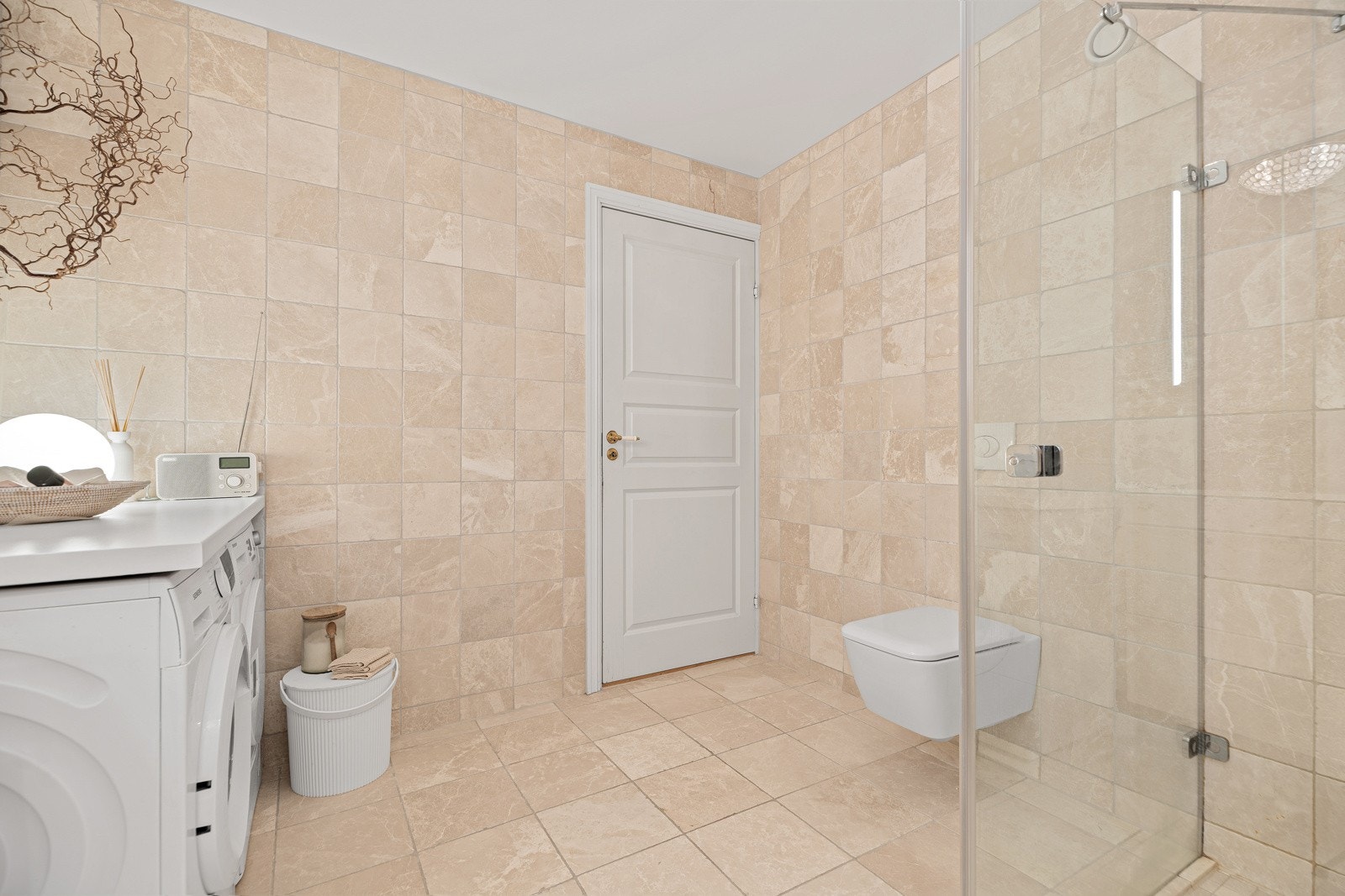 Pent flislagt bad med vegghengt wc, dusjhjørne, vask og opplegg til vaskemaskin/tørketrommel Galleribilde