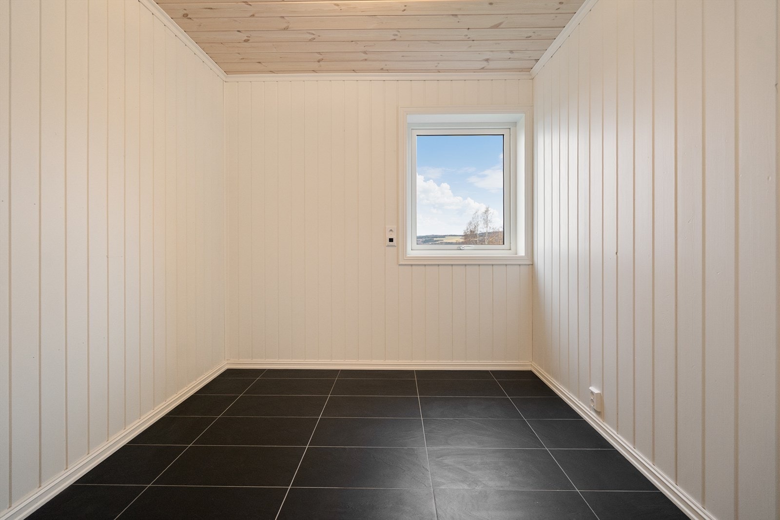 Flislagt gulv og panelte vegger gir et moderne preg til rommet. Galleribilde