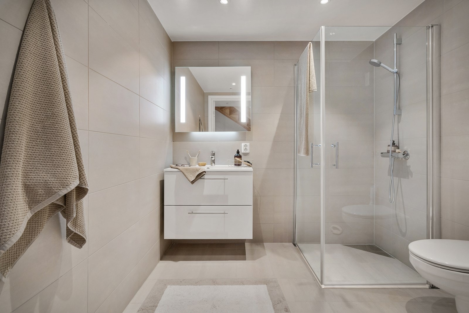 Etasjens bad står i også i stil med resten av boligen og inneholder innredning med nedfelt servant, veggmontert toalett, dusjvegger/hjørne og opplegg for vaskemaskin. Galleribilde