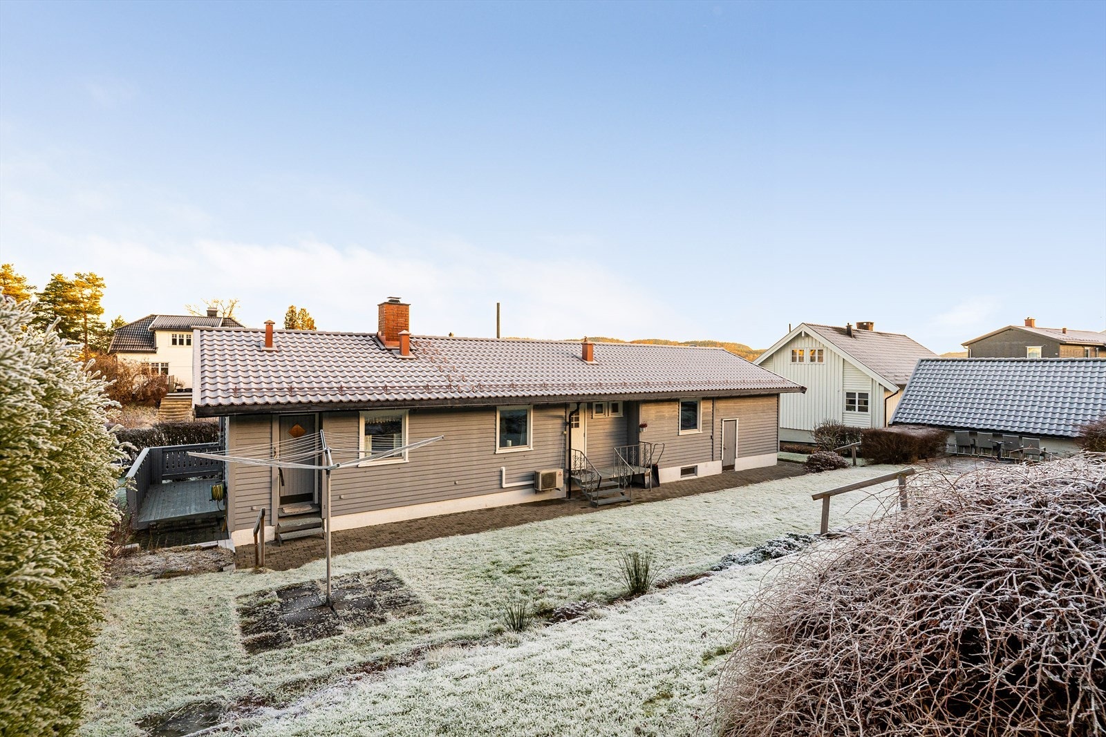 Romslig tomt i skrånende terreng, pent opparbeidet med plen, bed og diverse prydvekster, samt hekk. Galleribilde