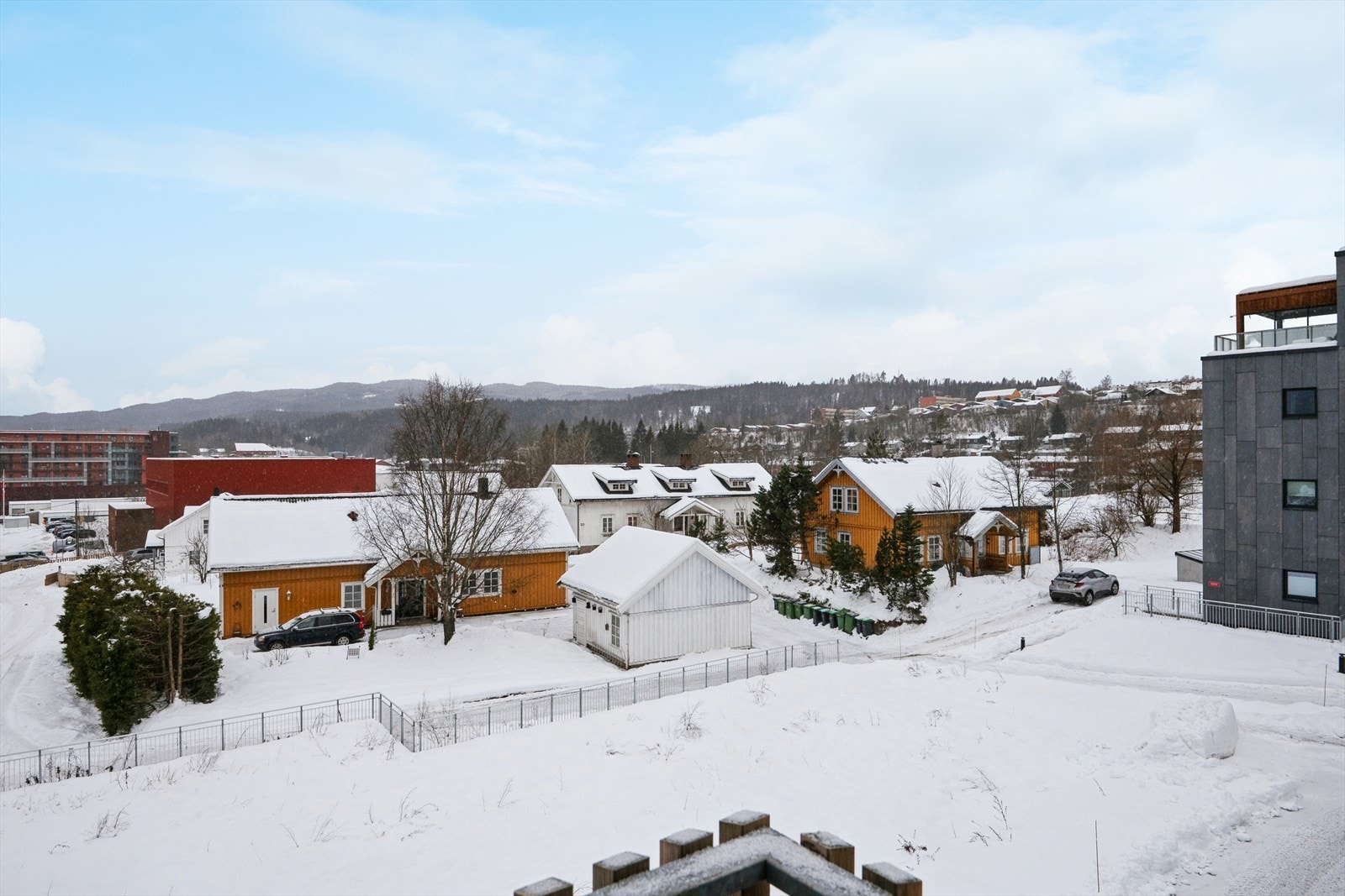 Du har utsikt mot både Nordmarka (som du ser her) og Romeriksåsen som ligger på andre siden av dalen. I den røde blokken du ser til venstre i bildet, finner du Mosenteret som kan tilby et rikt utvalg av butikker og forretninger. Galleribilde