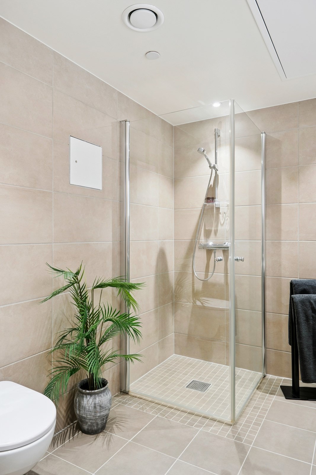 Romslig dusj med innsvinbare dusjvegger som gjør at du sparer gulvplass når dusjen ikke er i bruk. Du har også her inne et vegghengt toalett. Galleribilde