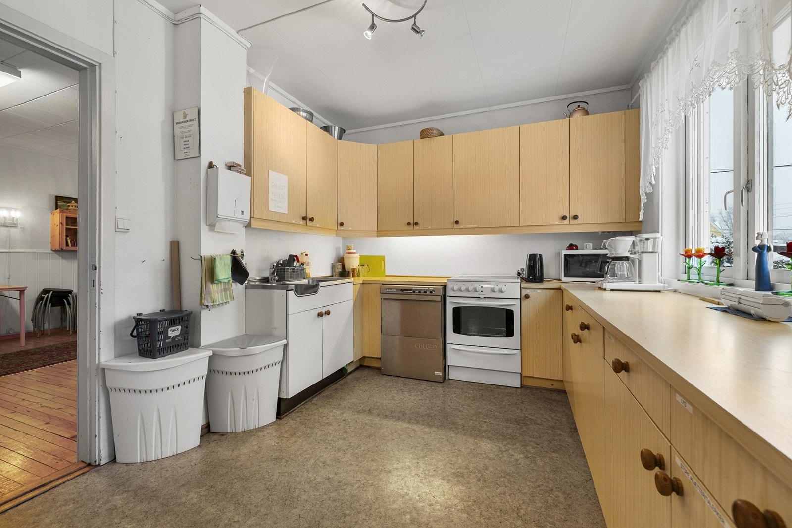 Kjøkkenet er utstyrt med flere hvitevarer og en praktisk oppvaskbenk i stål. Galleribilde