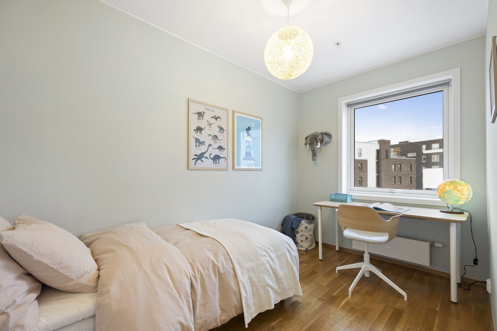 Lunt barnerom med plass til seng, nattbord, skrivebord og kontorstol. Plass til garderobeskap for oppbevaring av klær Galleribilde