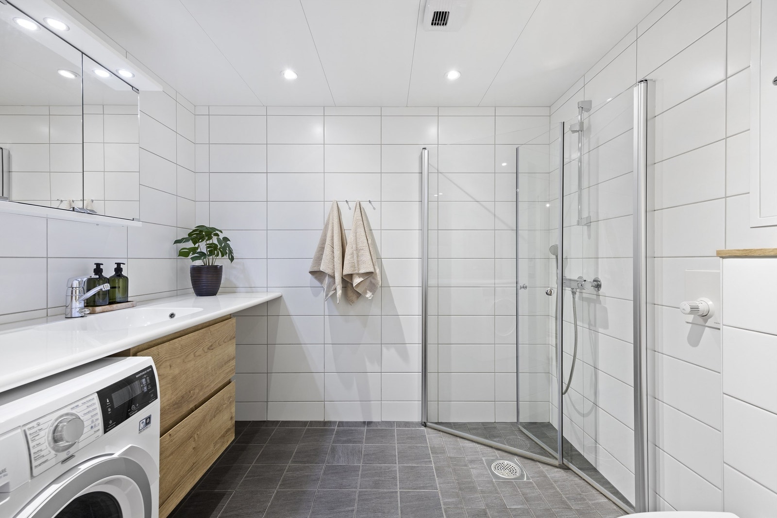 Lekkert og flislagt baderom med gulvvarme. Plass og opplegg til vaskemaskin og tørketrommel Galleribilde