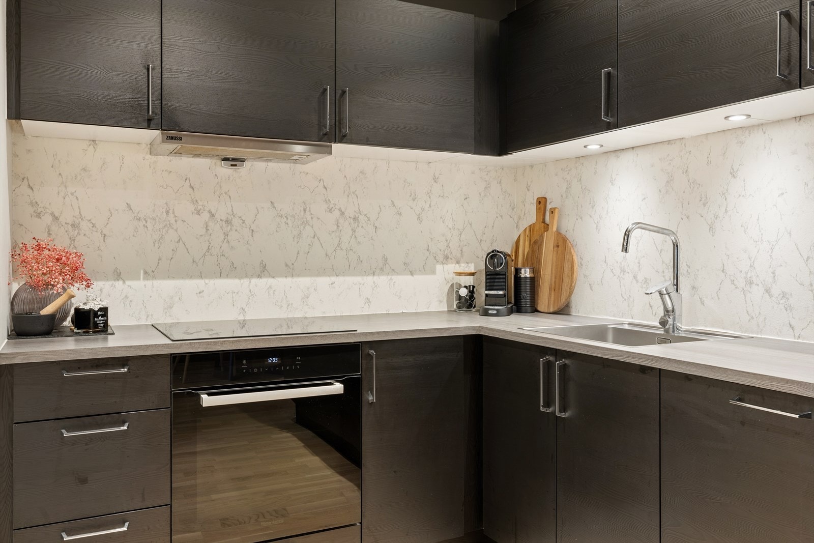 Kjøkkenet har en tidløs og elegant innredning med glatte, mørke fronter og laminatbenkeplate med underlimt stålvask. Galleribilde