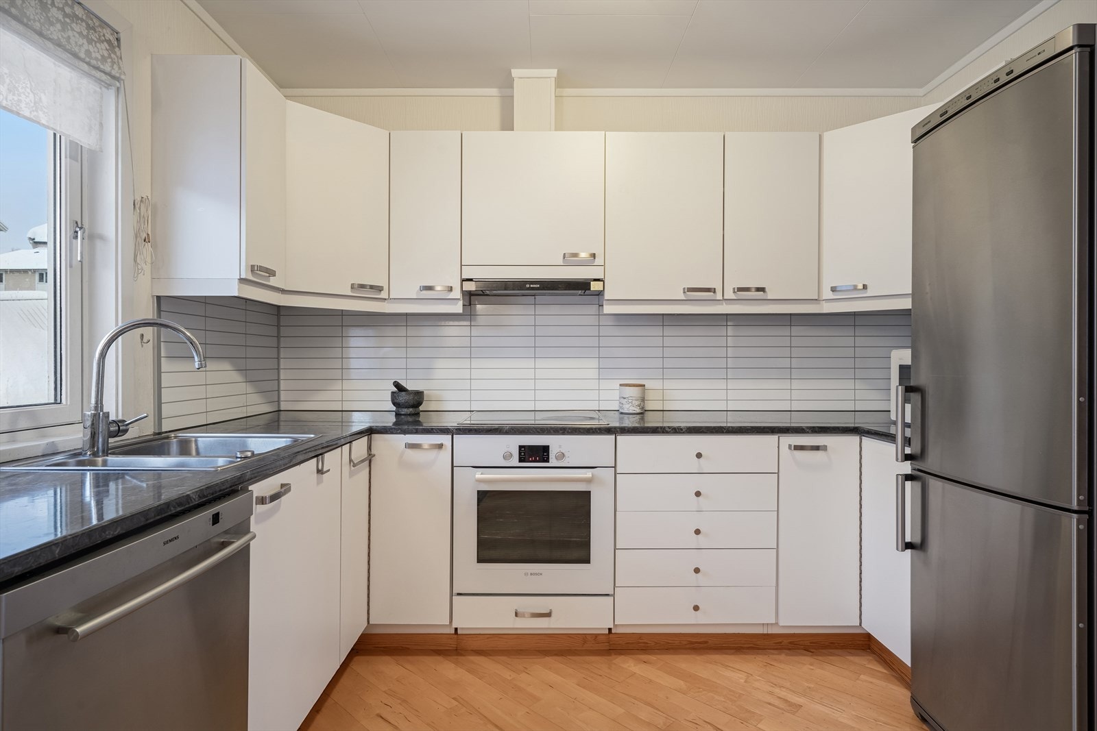 på kjøkkenet får du godt med skap- og benkeplass takket være laminerte fronter og en solid benkeplate. Galleribilde