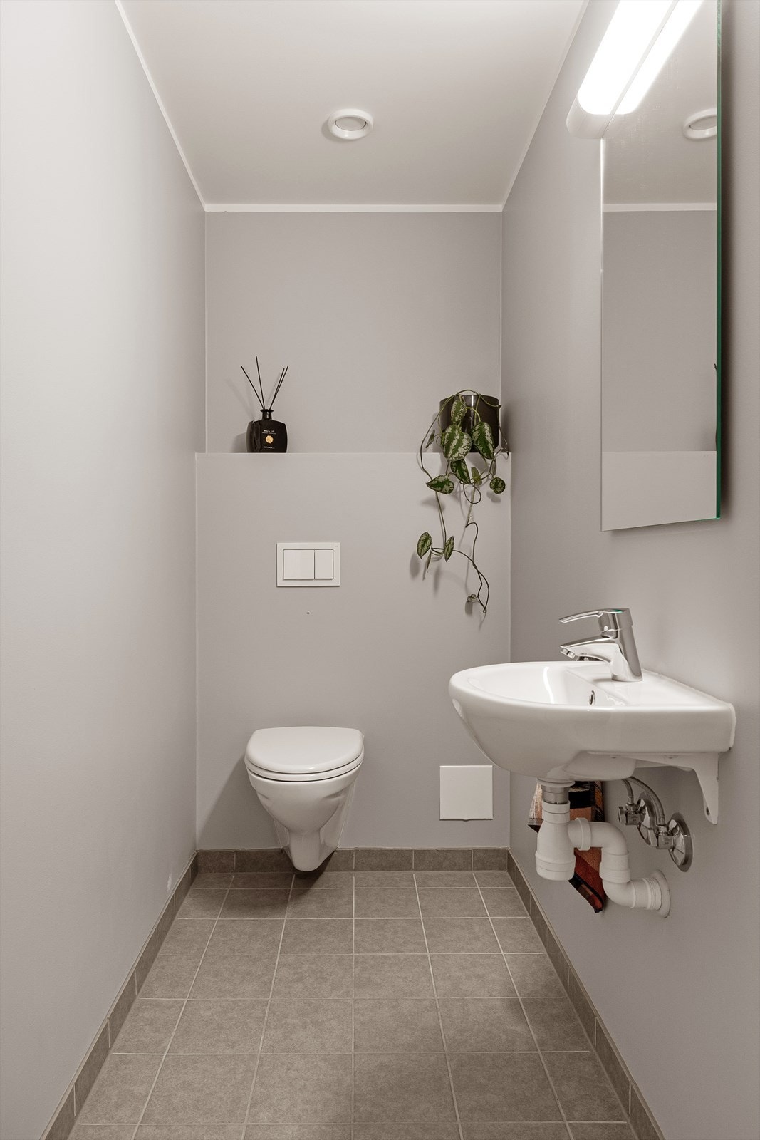 I tilknytning til entréen har boligen et separat toalettrom. Rommet har flislagt gulv samt malte overflater på vegger og i himling. Toalettet er utstyrt med veggmontert wc, hvit servant med blandebatteri og mekanisk avtrekk. Galleribilde