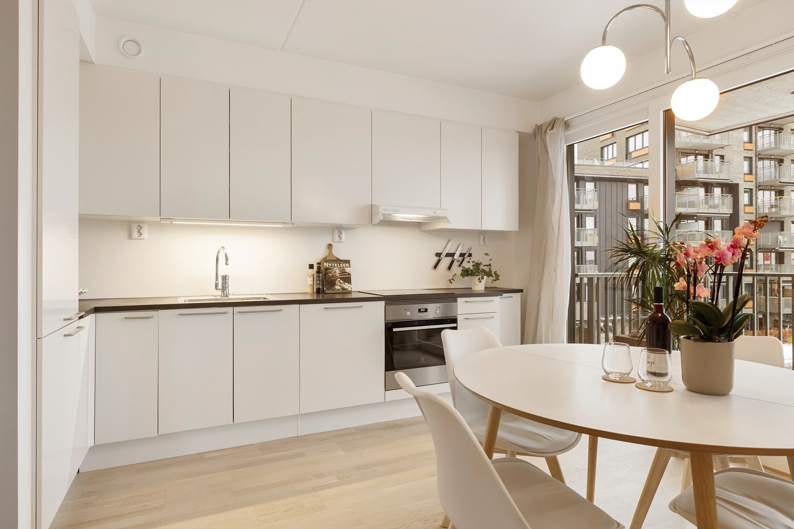 Pent HTH kjøkken fra byggeår med glatte fronter og laminert benkeplate. Galleribilde