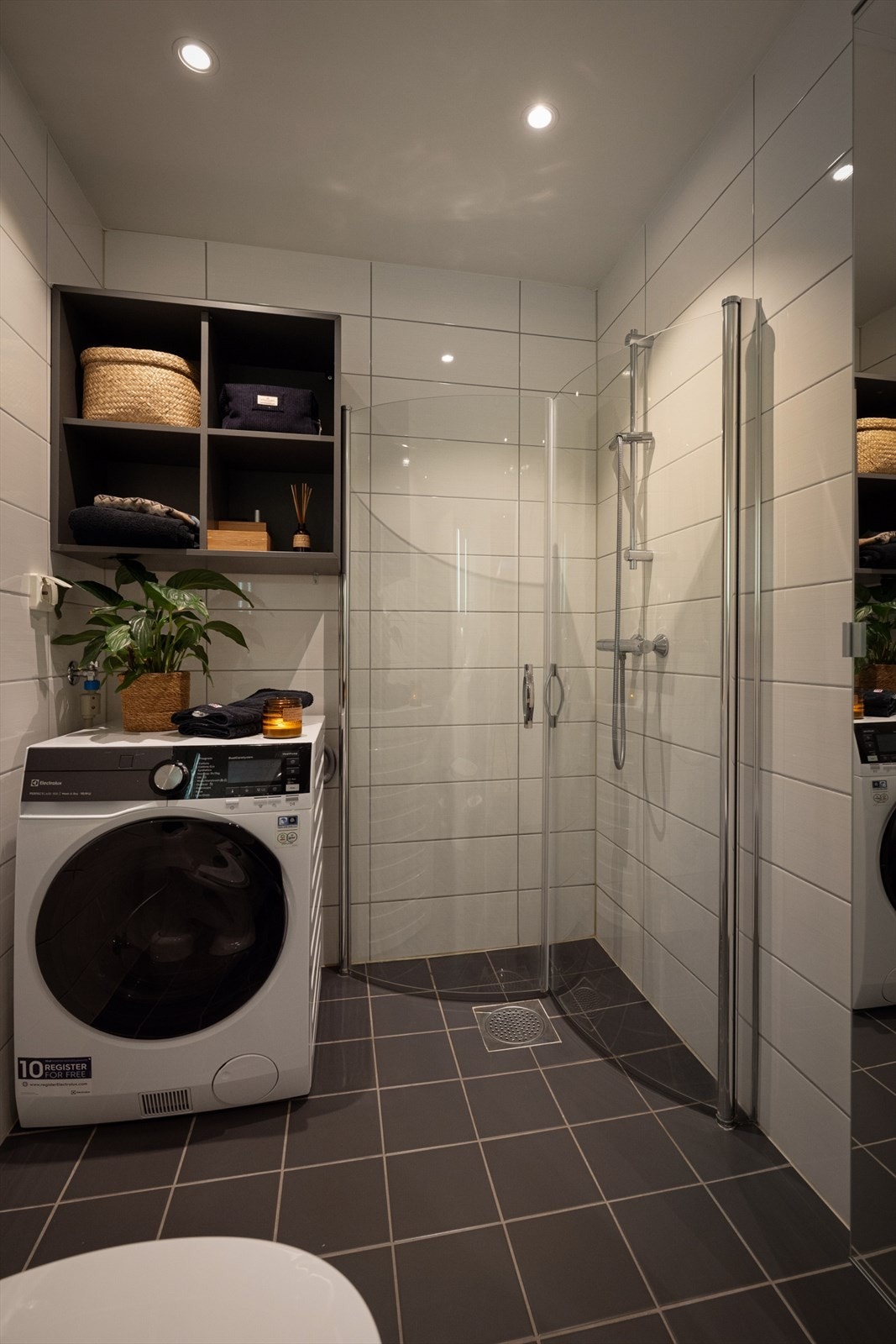 Rommet er innredet med nedfelt servant og glatte fronter, speil på vegg , toalett, dusj på gulv og opplegg for vaskemaskin. Galleribilde