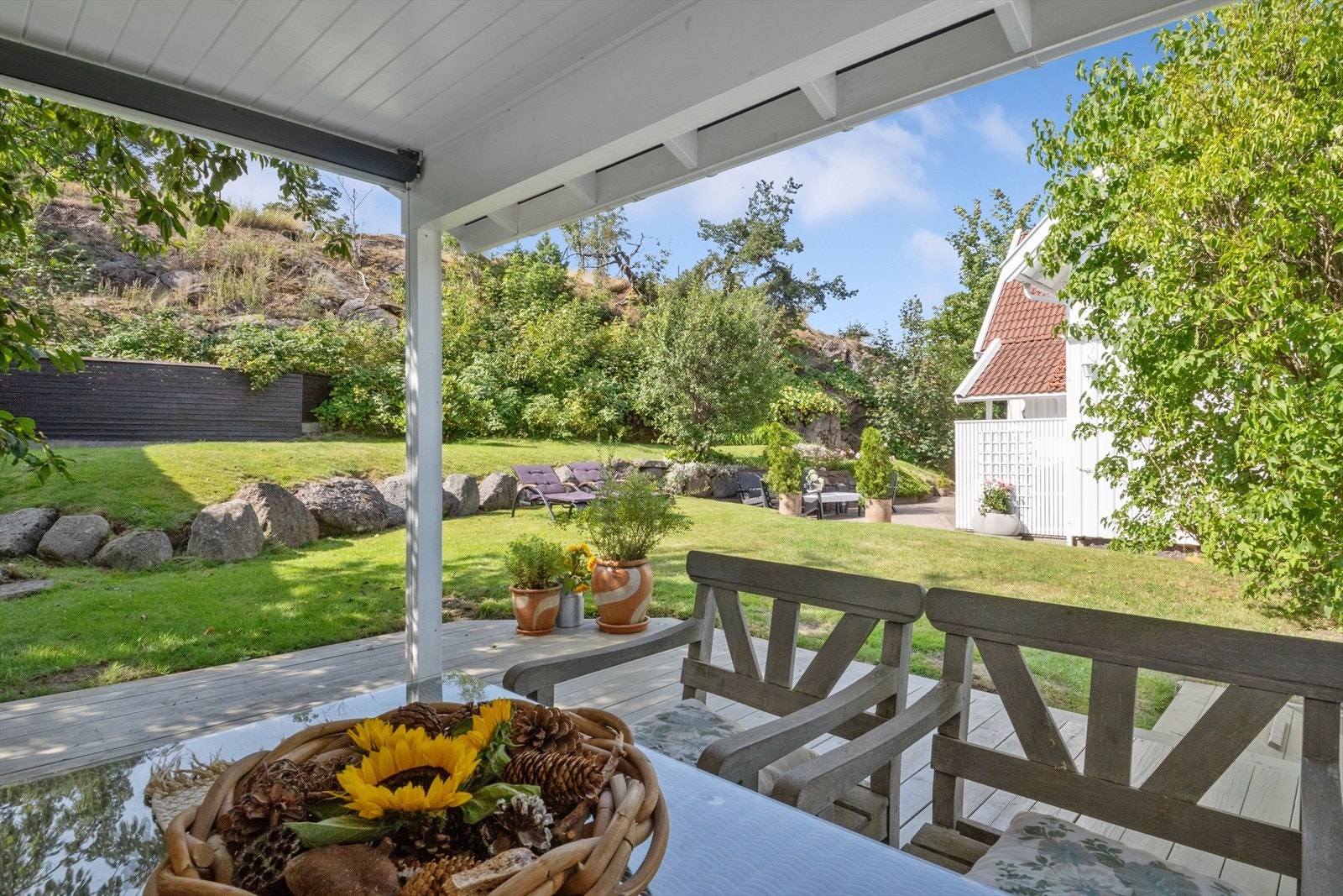 Den overbygde terrassen gir utsikt over hagen. Galleribilde