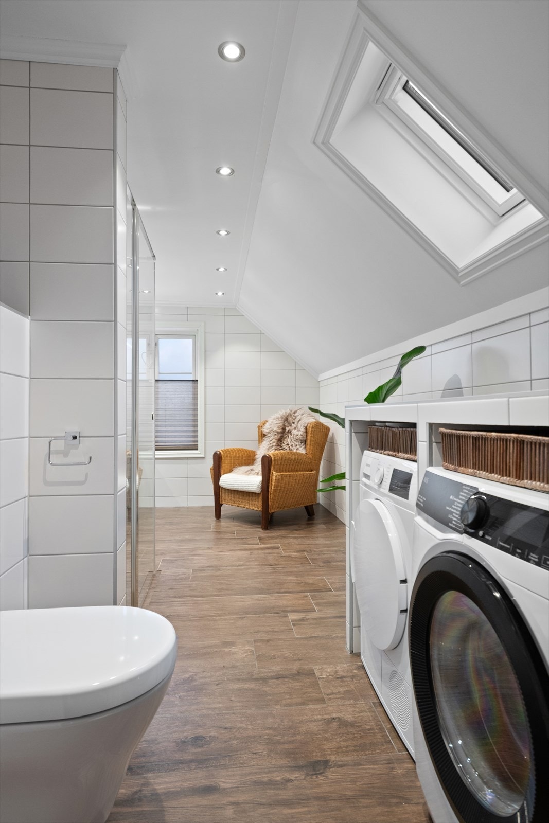 Badet er utstyrt med fliser på gulv og vegger, vegghengt toalett, dusjhjørne med innfellbare glassdører og opplegg for vaskemaskin. Galleribilde