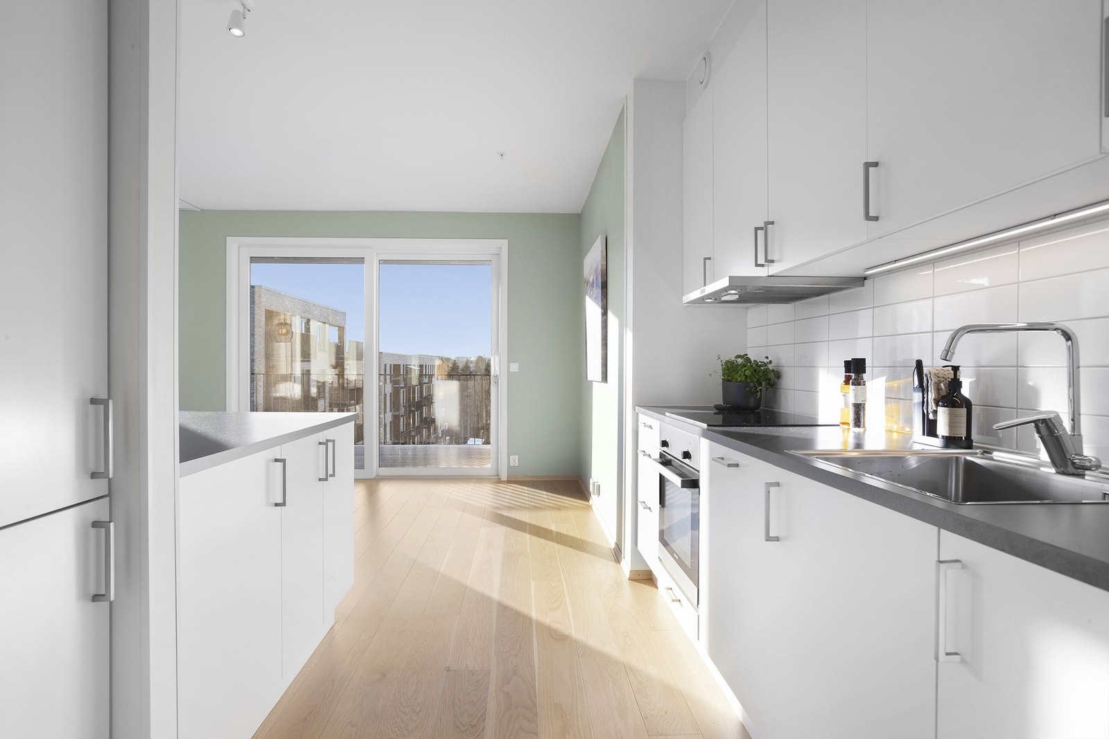 Kjøkkenet fremstår tidløst med slette fronter og detaljer i krom. Galleribilde