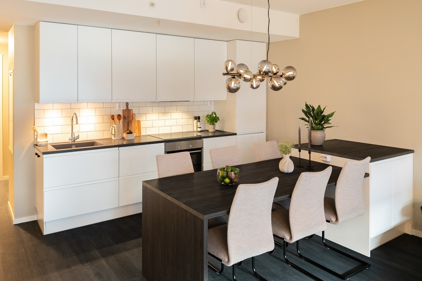 Leiligheten har en åpen stue- og kjøkkenløsning som måler 31 m². I tilknytning til kjøkkenet er det etablert en praktisk barløsning med ekstra oppbevaring og en tilhørende spisegruppe. Galleribilde