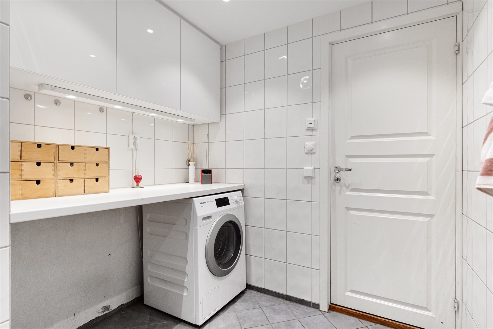 Baderommet har egen definert vaskeromsdel med praktisk overskap og hylle. Her er det god plass til både vaskemaskin og tørketrommel. Galleribilde
