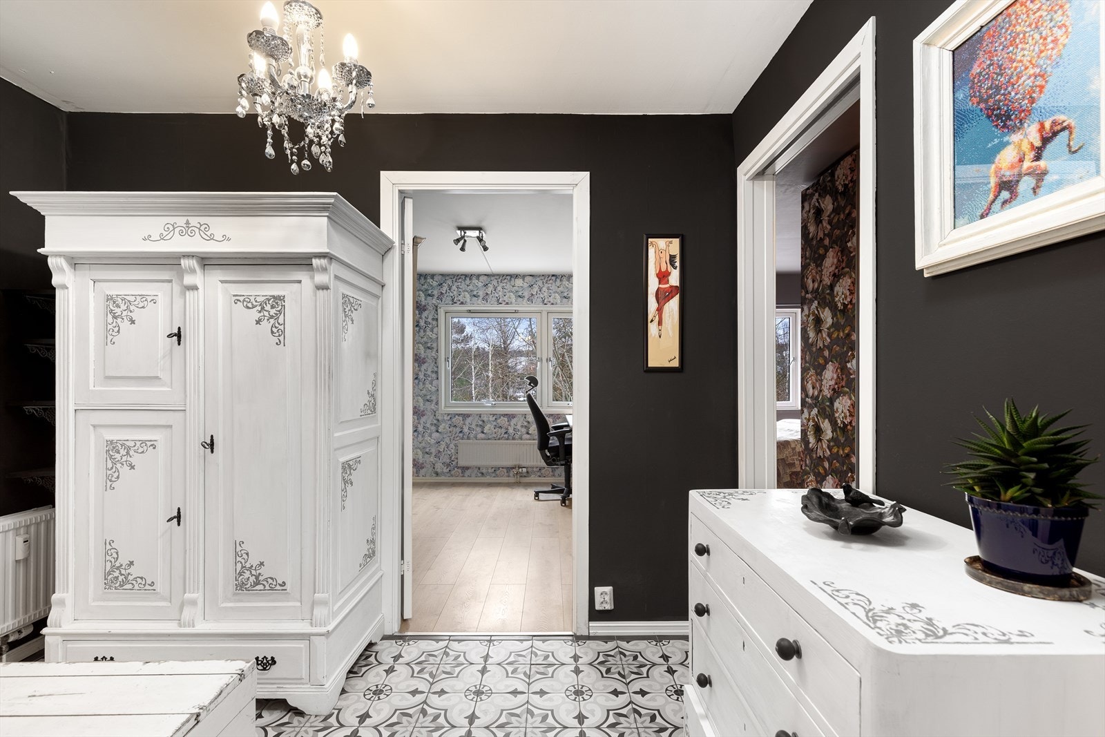 Gangen har malte flater på vegger og flottedekorative, klassiske sementfliser som gir boligen særpreg og karakter. Galleribilde