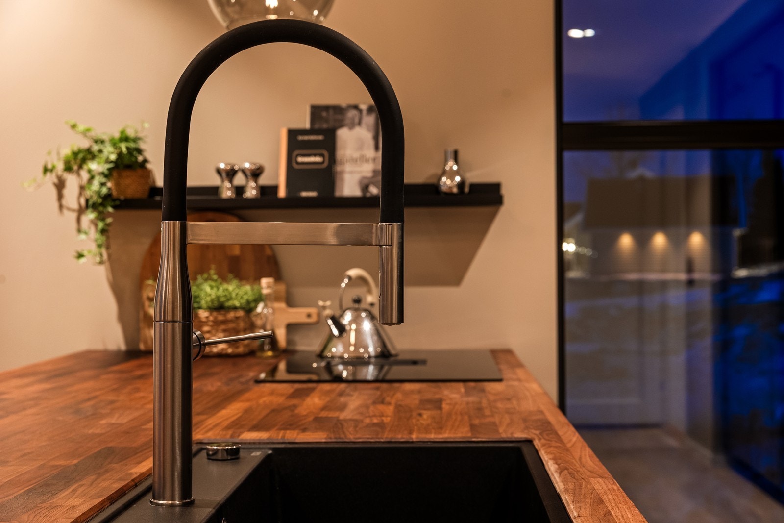 Detaljer som sort blandebatteri og integrert platetopp understreker den gjennomførte stilen. Galleribilde