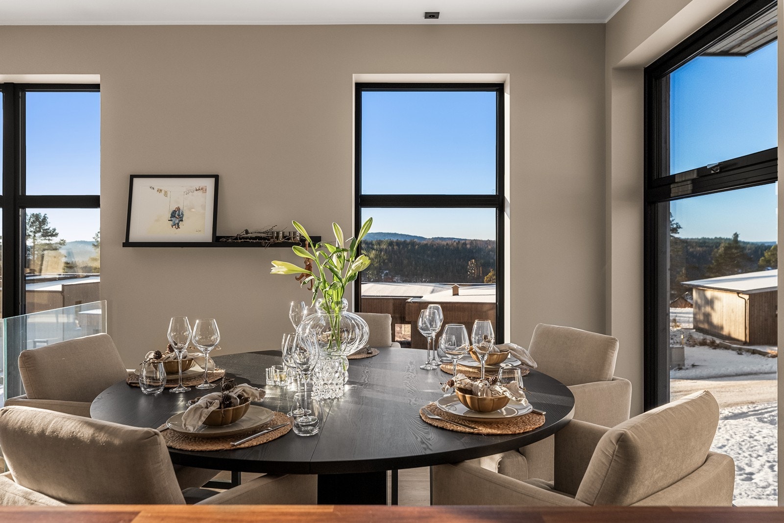 Spisestuen har plass til et stort spisebord og er rammet inn av store vinduer. Galleribilde