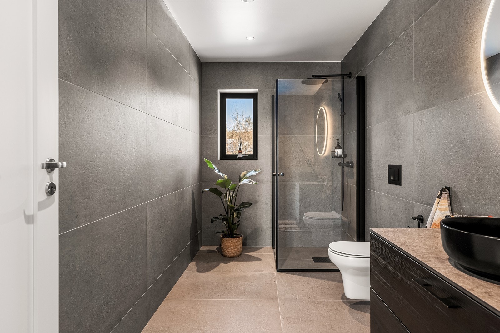 Badet i 1. etasje er stilrent med store fliser og et romslig dusjhjørne. Galleribilde