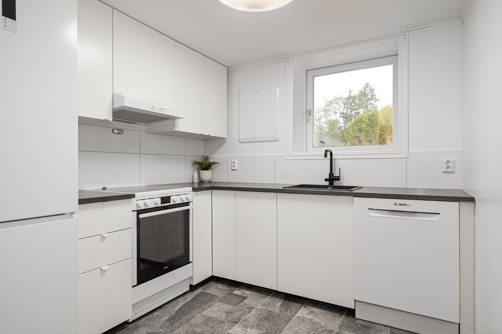 Pent kjøkken med godt av skap- og benkeplass. Galleribilde