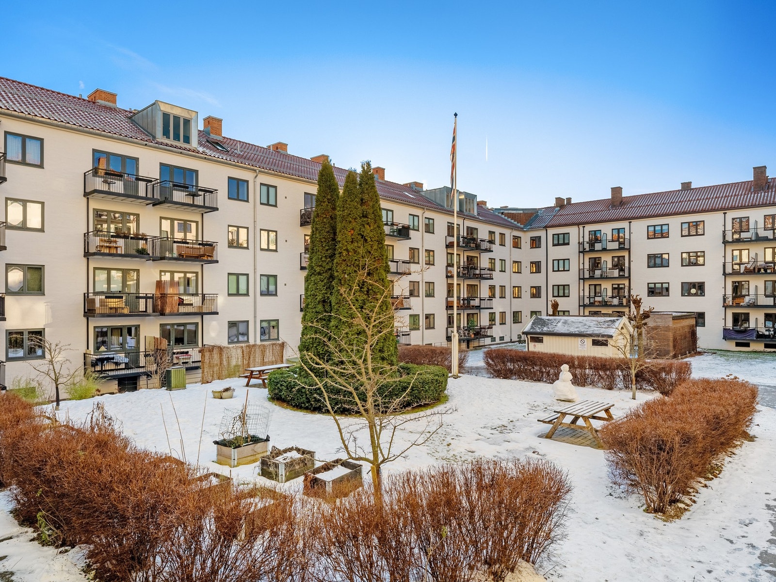 Pent opparbeidet bakgård med sittebenker og beplantning. Galleribilde