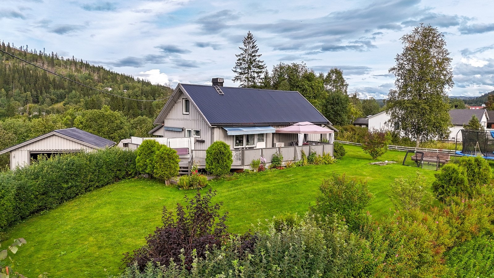 Eiendommen har en særs pent opparbeidet hage. Her med masse busker, hekk og blomster. Galleribilde