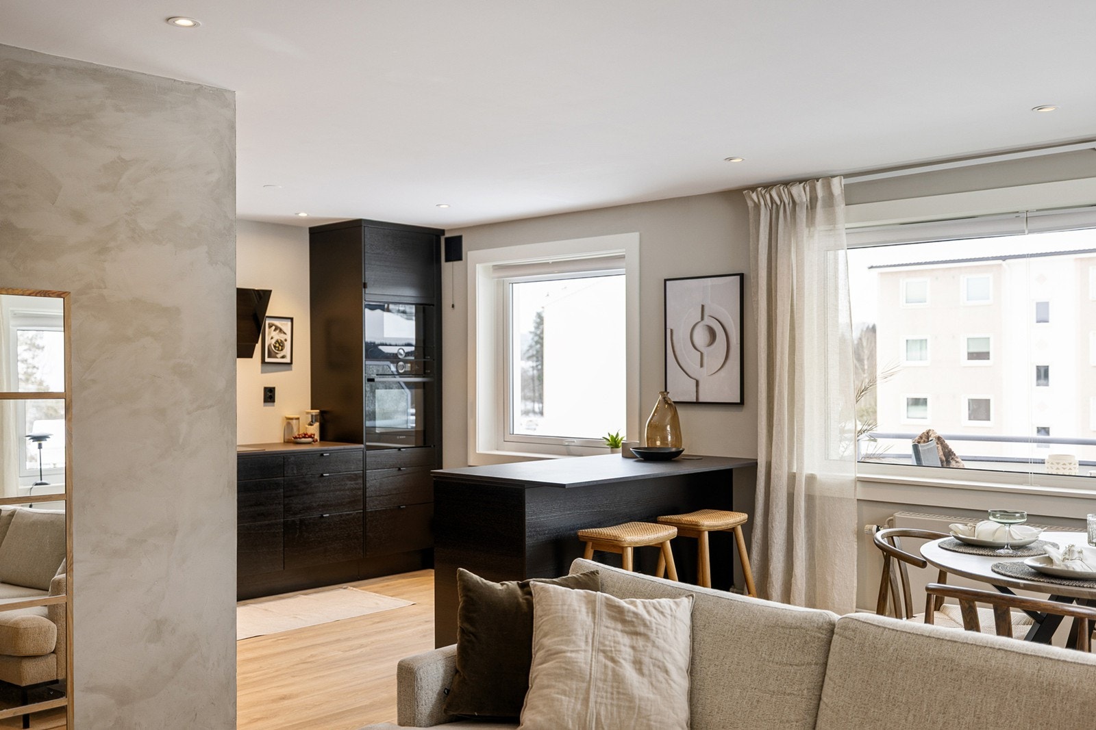 Lys og romslig stue i åpen løsning mot kjøkkenet, med store vindusflater som gir rikelig med naturlig lys. Galleribilde